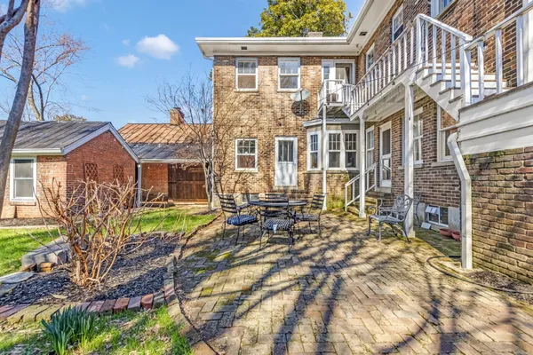 a view of a house with a big yard and large tree