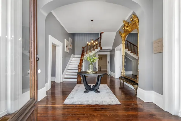 a view of a hallway with wooden floor and a dining room