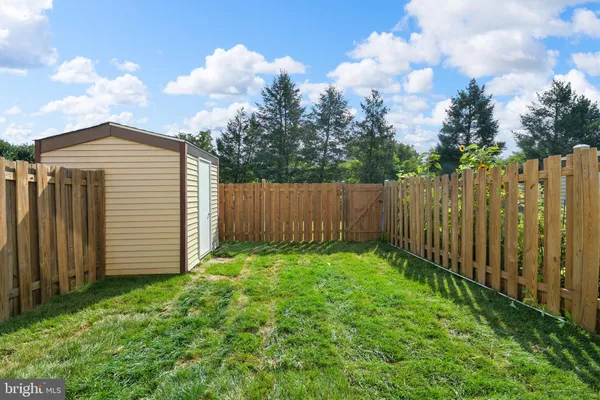 a view of a backyard with wooden fence