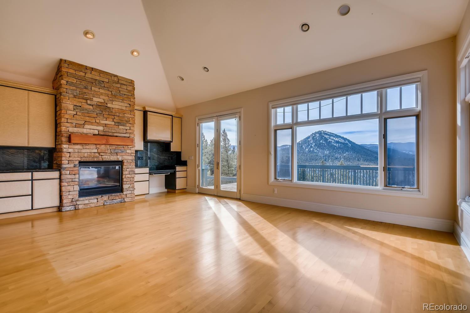 3883 Mountainside Trail Evergreen, CO 80439 - Photo 14 of 36 a view of an empty room with a fireplace and a window