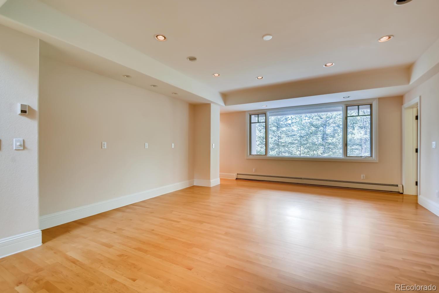 3883 Mountainside Trail Evergreen, CO 80439 - Photo 15 of 36 a view of an empty room with wooden floor and a window