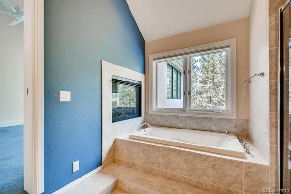 a spacious bathroom with bathtub and shower