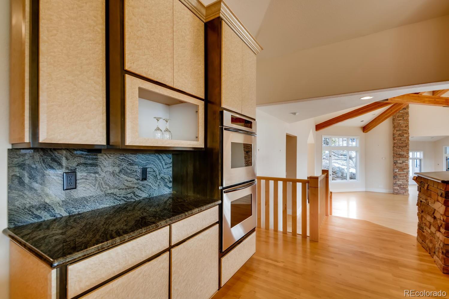 3883 Mountainside Trail Evergreen, CO 80439 - Photo 8 of 36 a kitchen with stainless steel appliances granite countertop a stove a sink and a microwave