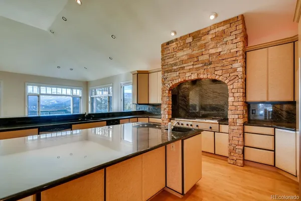 a view of a kitchen with kitchen island a sink wooden floor and a counter top space