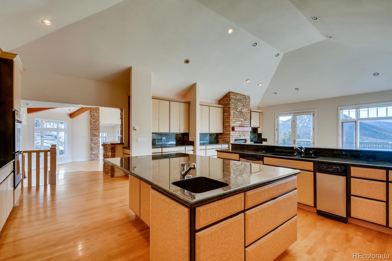 3883 Mountainside Trail Evergreen, CO 80439 - Photo 10 of 36 a kitchen with stainless steel appliances granite countertop a sink a stove and a refrigerator