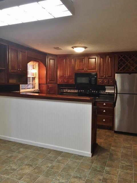 109 Ryans Path Morrison, TN 37357 - Photo 6 of 29 a kitchen with granite countertop a refrigerator a stove a microwave and cabinets