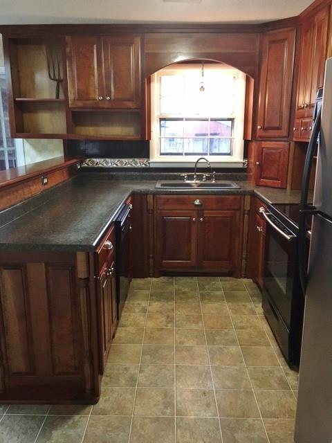 109 Ryans Path Morrison, TN 37357 - Photo 7 of 29 a kitchen with granite countertop a refrigerator a sink and wooden cabinets