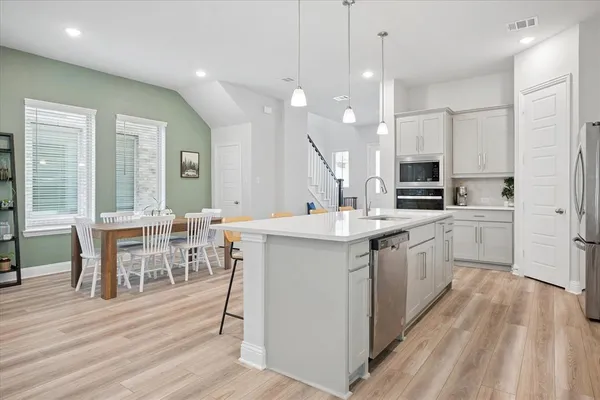 a kitchen with kitchen island granite countertop a sink cabinets and wooden floor