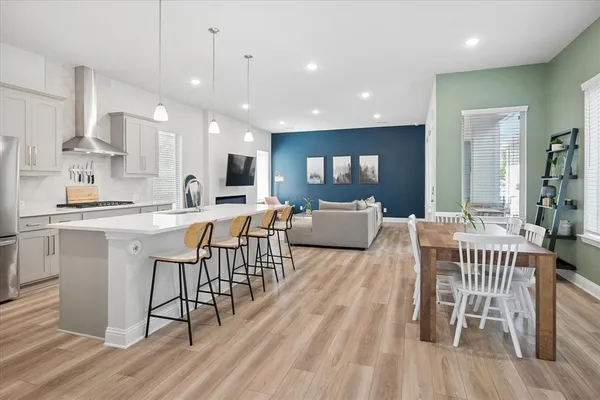 a living room with furniture a wooden floor and kitchen view