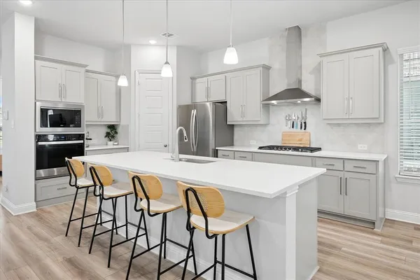 a kitchen with stainless steel appliances a table chairs refrigerator and sink