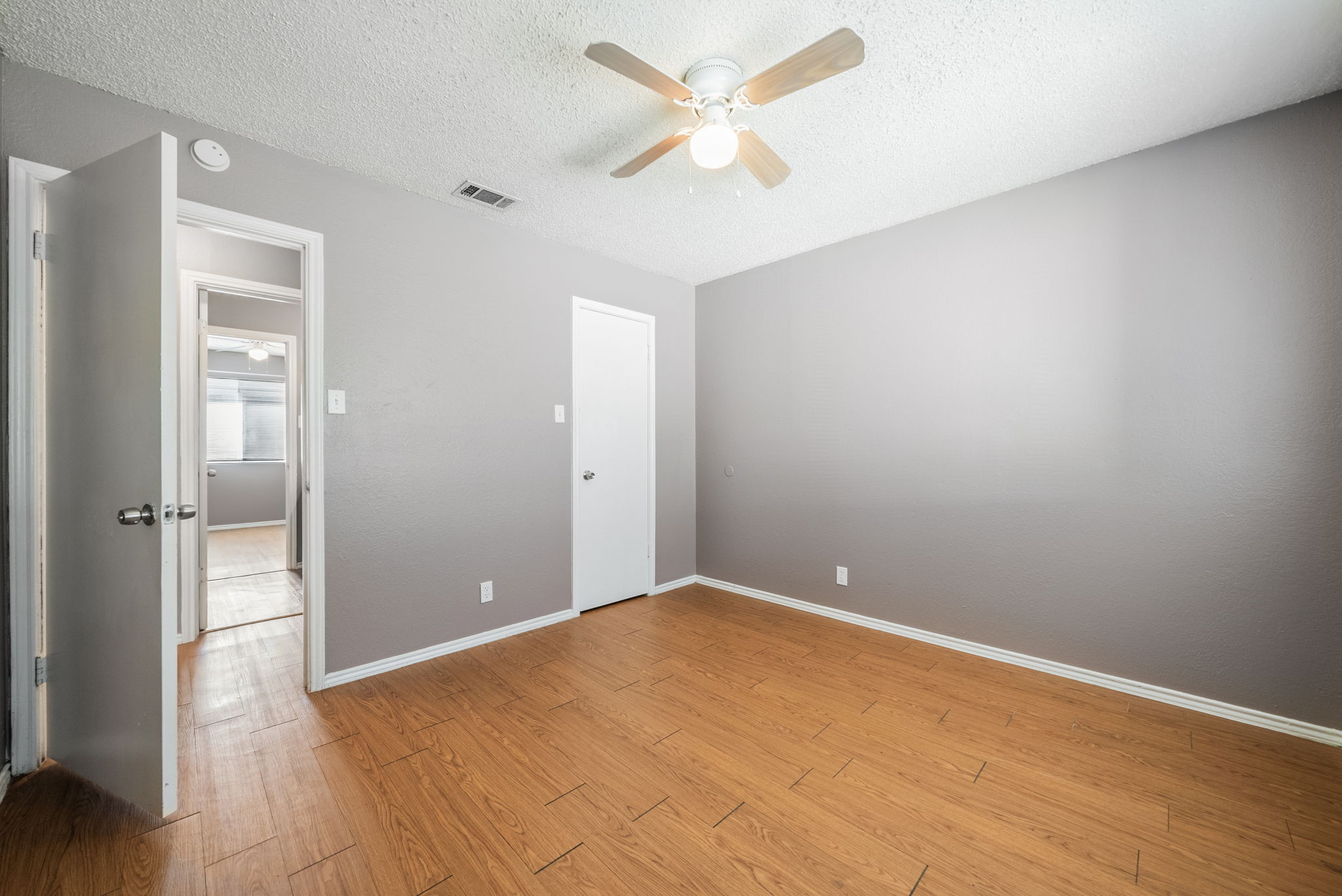 5807 Spring Meadow Road, Unit B Austin, TX 78744 - Photo 27 of 31 A well-lit bedroom features durable laminate flooring and a ceiling fan for comfort.