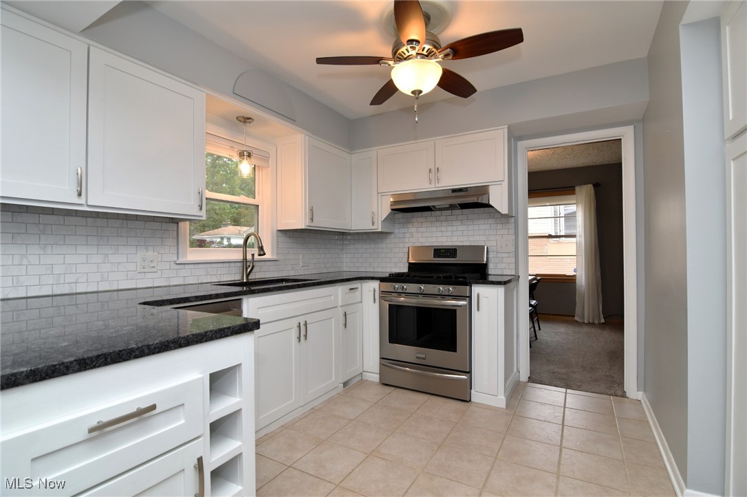 2071 Wyndham Road Akron, OH 44313 - Photo 10 of 42 Kitchen with plenty of natural light, stainless gas range, sink, and white cabinetry.