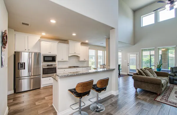 a kitchen with stainless steel appliances granite countertop a refrigerator and a stove top oven