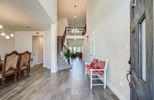 a dining room with furniture a chandelier and wooden floor