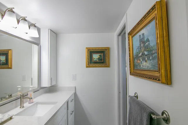 a bathroom with a granite countertop sink mirror and vanity