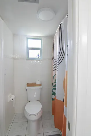 a bathroom with a toilet and a mirror