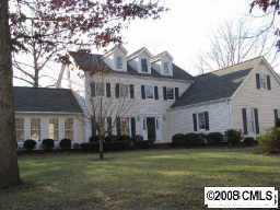 a view of a white house with a big yard and large trees