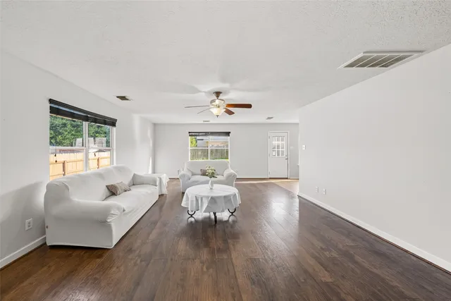 a living room with furniture and wooden floor