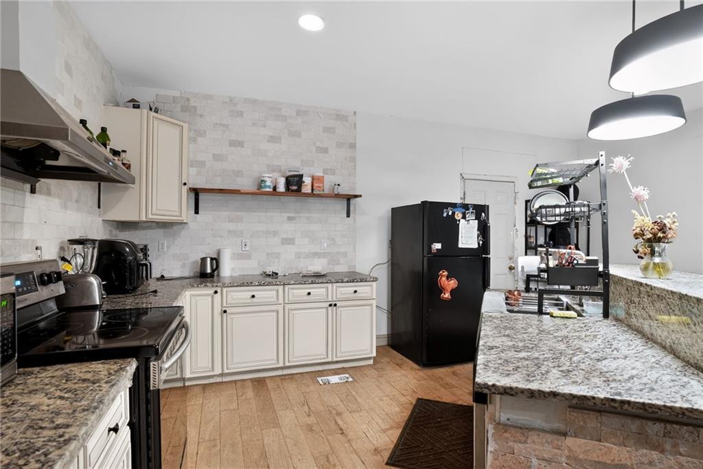 843 Fox Street Northwest Atlanta, GA 30318 - Photo 12 of 30 a kitchen with stainless steel appliances granite countertop a stove refrigerator and cabinets