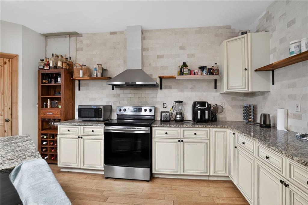 843 Fox Street Northwest Atlanta, GA 30318 - Photo 13 of 30 a kitchen with stainless steel appliances granite countertop a sink and cabinets