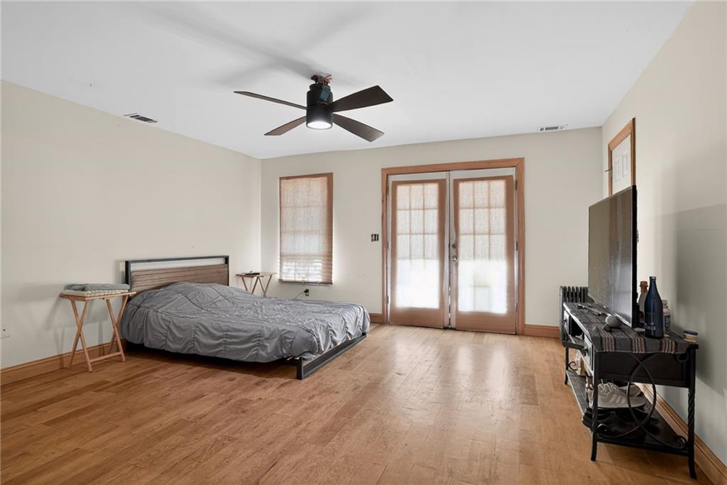 843 Fox Street Northwest Atlanta, GA 30318 - Photo 14 of 30 a spacious bedroom with a bed windows and a chandelier