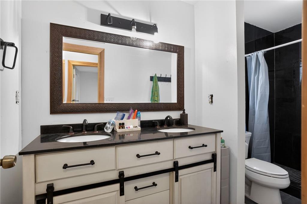 843 Fox Street Northwest Atlanta, GA 30318 - Photo 17 of 30 a bathroom with a toilet sink and mirror