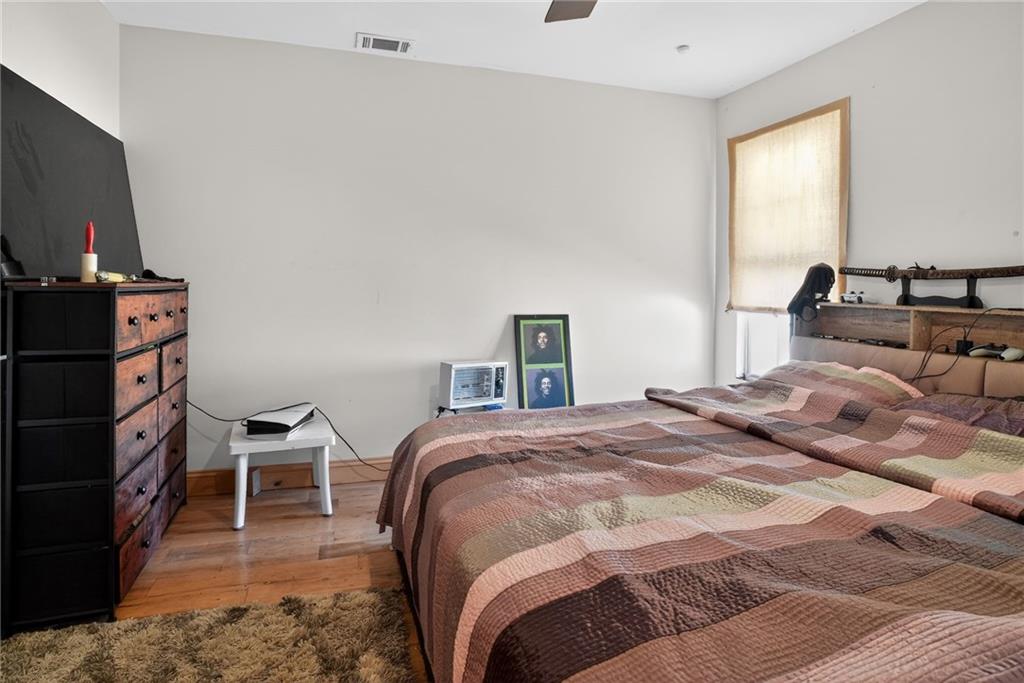 843 Fox Street Northwest Atlanta, GA 30318 - Photo 21 of 30 a bedroom with a bed and a flat tv screen on the dresser