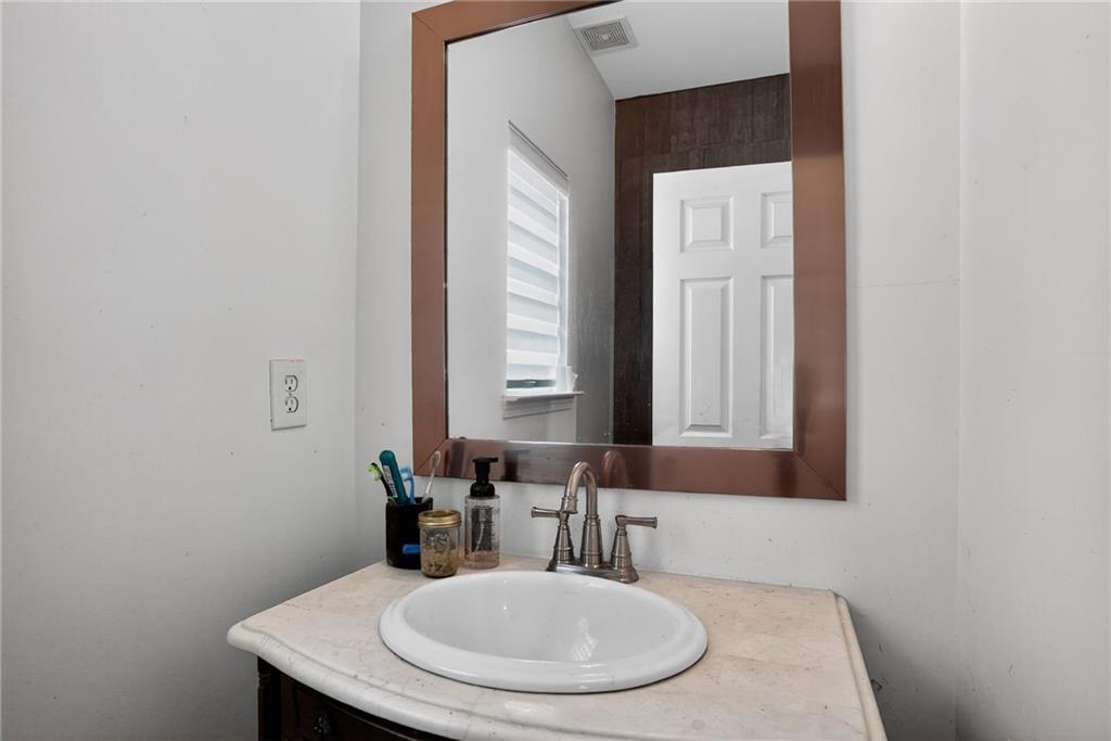 843 Fox Street Northwest Atlanta, GA 30318 - Photo 26 of 30 a bathroom with a granite countertop sink a mirror and a window