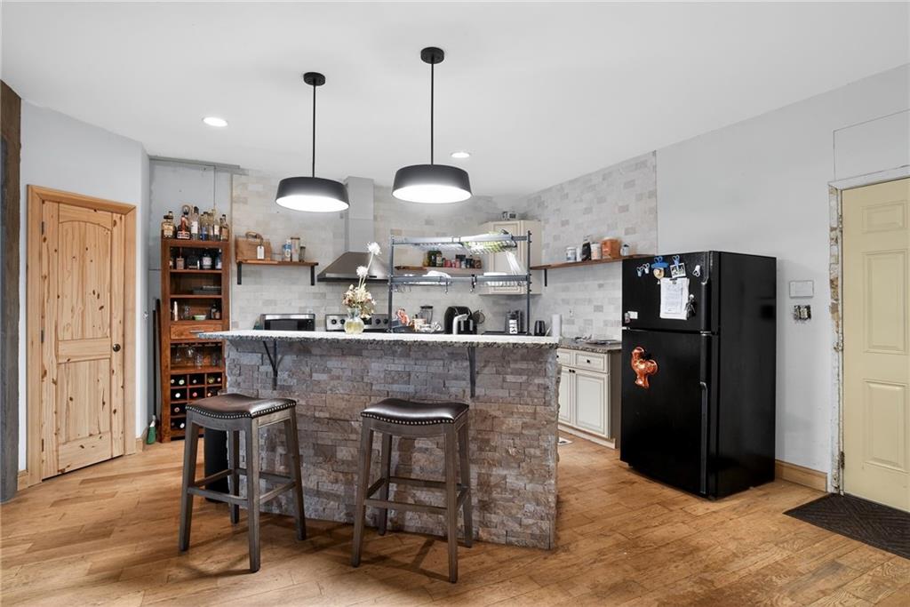 843 Fox Street Northwest Atlanta, GA 30318 - Photo 9 of 30 a kitchen with stainless steel appliances granite countertop a refrigerator a sink dishwasher a stove and a dining table with wooden floor