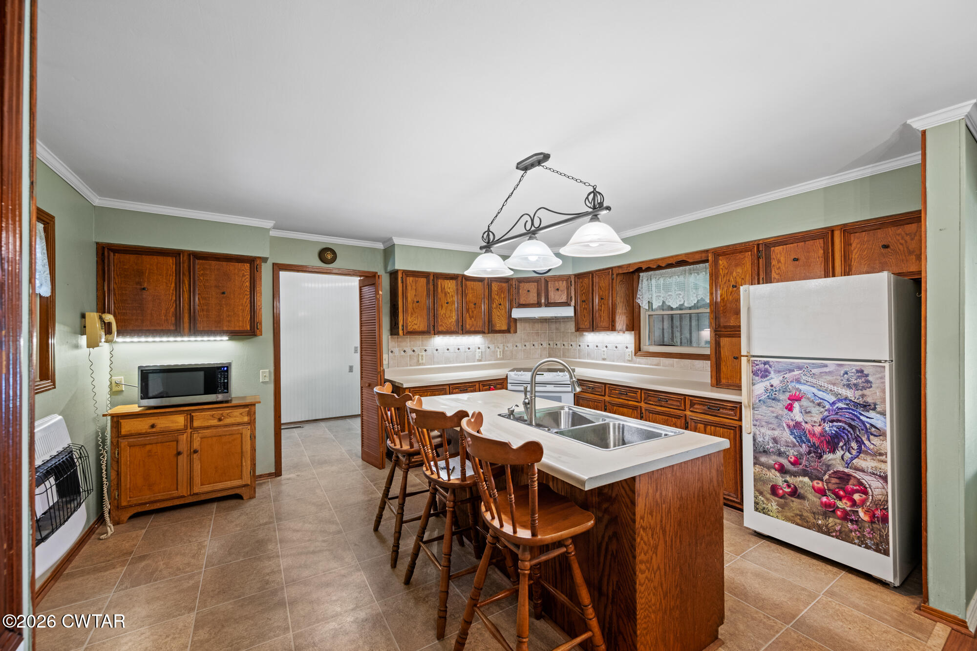 8932 Mt Carmel Road Decaturville, TN 38329 - Photo 3 of 47 a view of a dining room with furniture a kitchen and chandelier