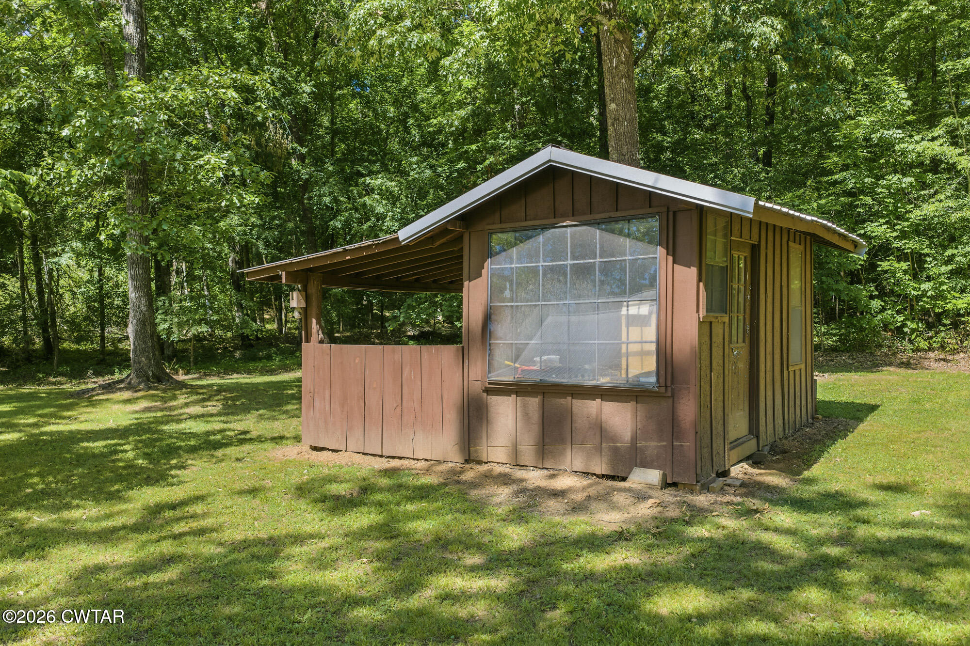8932 Mt Carmel Road Decaturville, TN 38329 - Photo 39 of 47 a view of a tiny house with yard and a large tree