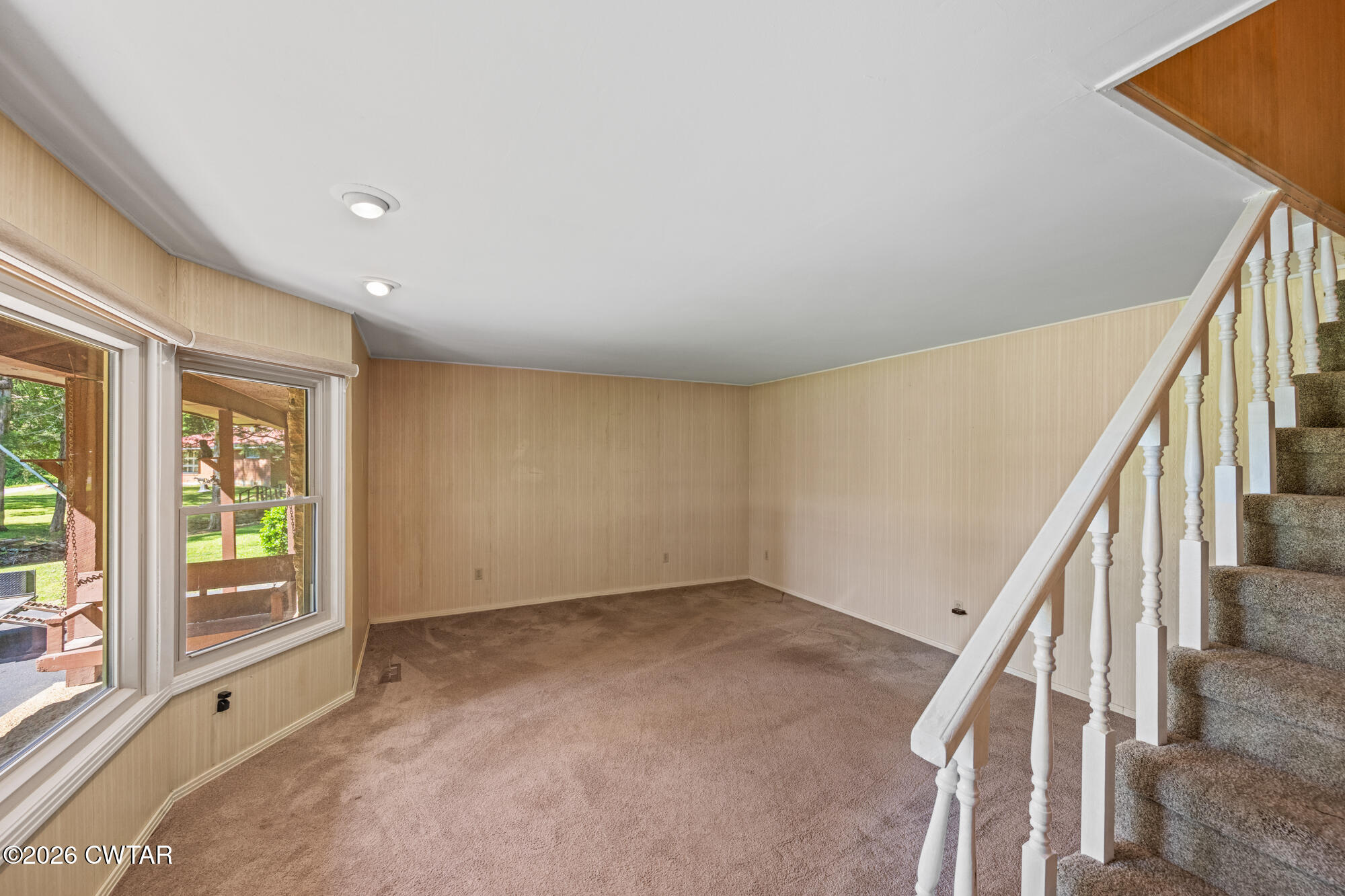 8932 Mt Carmel Road Decaturville, TN 38329 - Photo 9 of 47 a view of an empty room with wooden floor and stairs