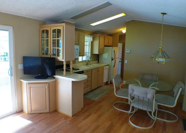 a kitchen with a sink cabinets and wooden floor