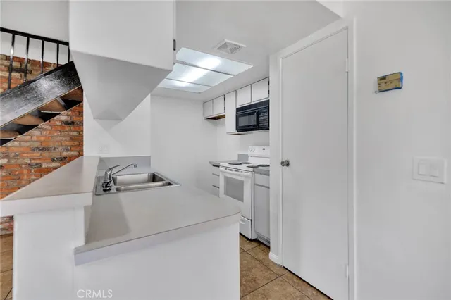 a kitchen with a sink stove and microwave