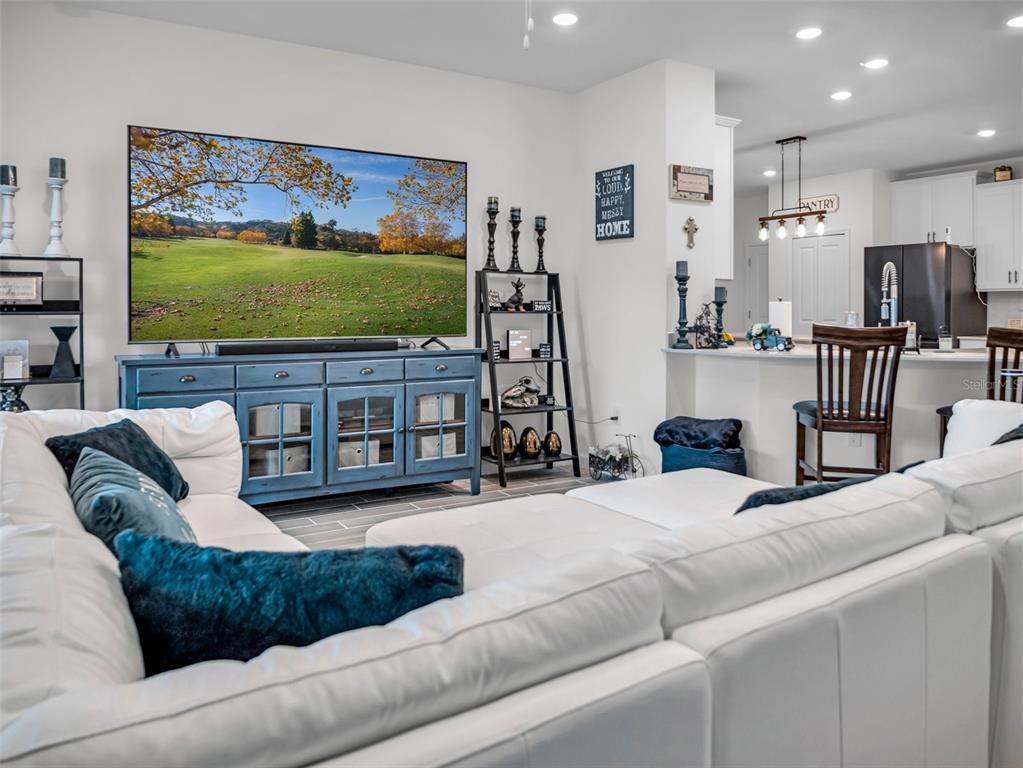 7474 Southwest 78th Terrace Ocala, FL 34481 - Photo 22 of 58 a living room with furniture a projector and a flat screen tv