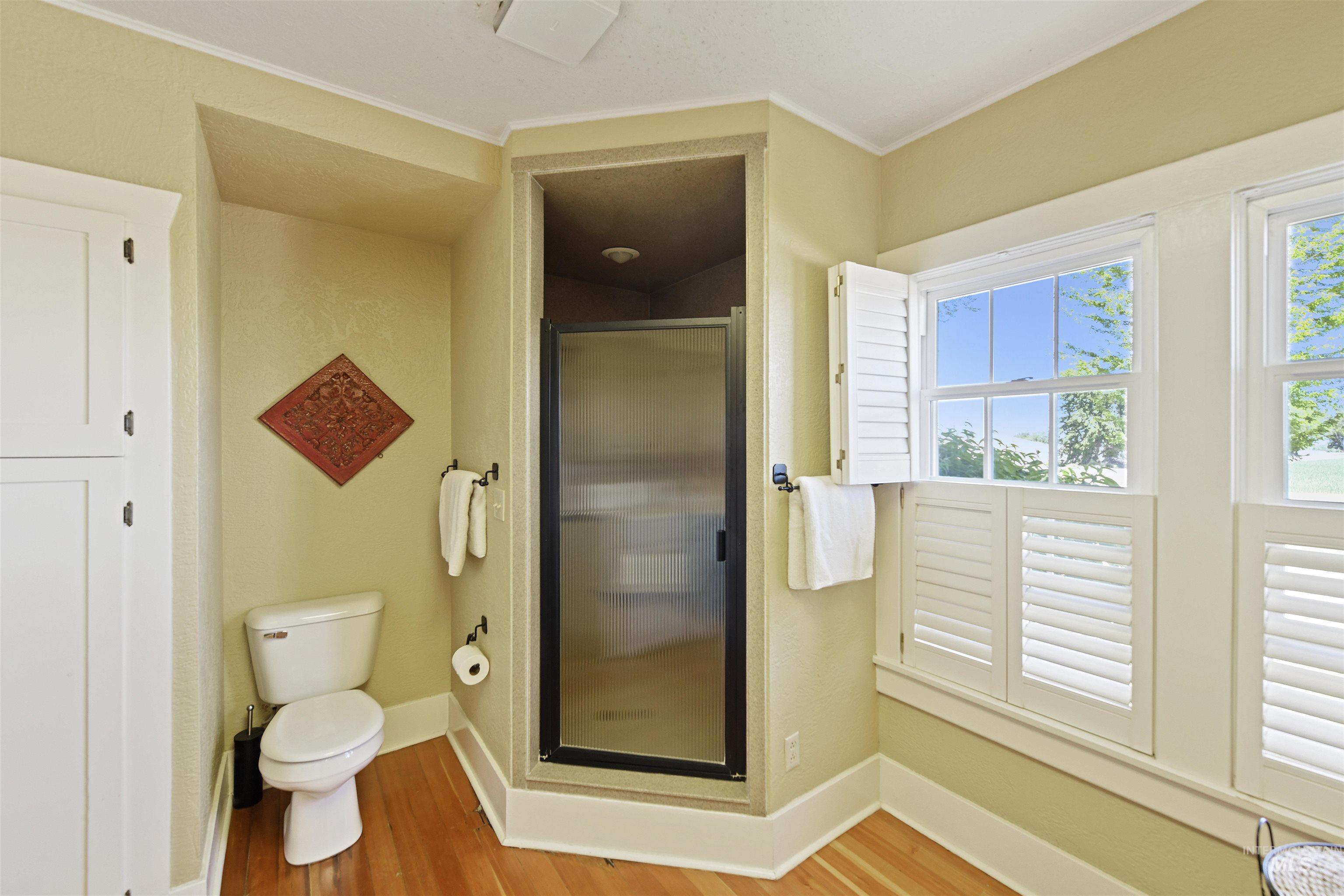 19234 Top Road Caldwell, ID 83607 - Photo 13 of 50 Bathroom with a stall shower, light wood-type flooring, and ornamental molding