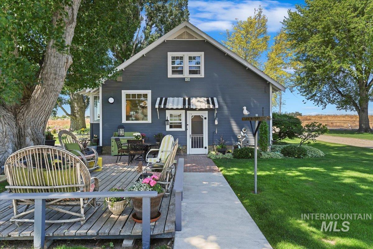 19234 Top Road Caldwell, ID 83607 - Photo 20 of 50 View of front of property featuring a front lawn, a deck, and outdoor dining area