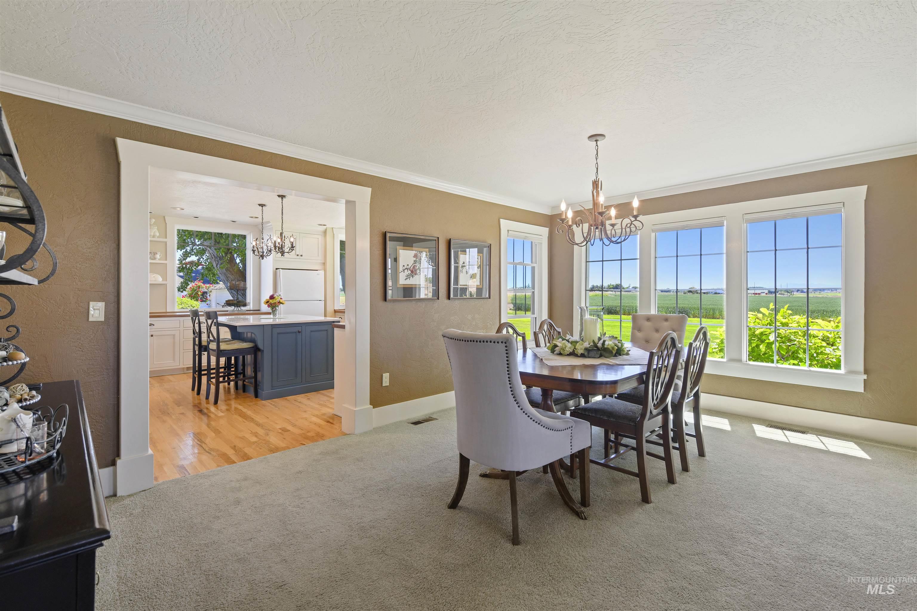 19234 Top Road Caldwell, ID 83607 - Photo 10 of 50 Dining space with a chandelier, crown molding, light carpet, and a textured ceiling