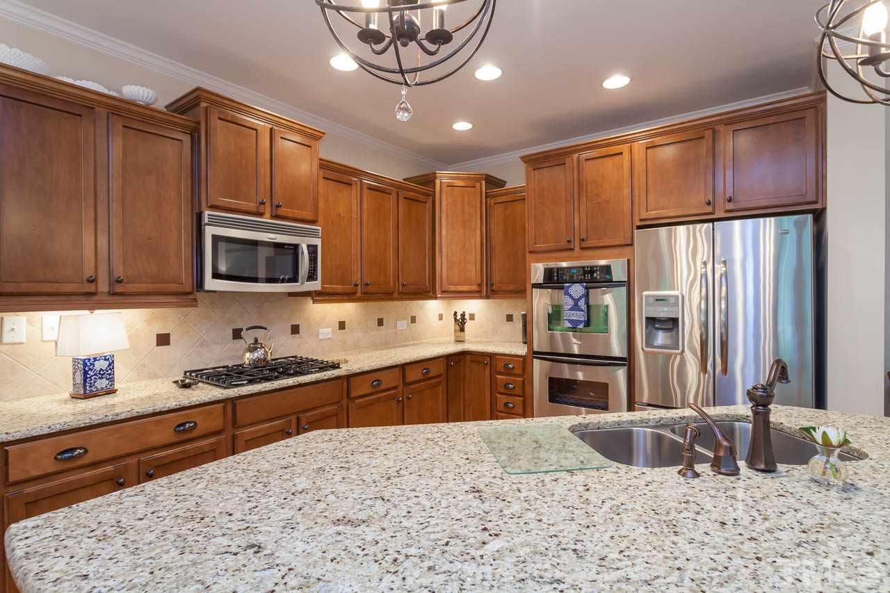 1014 Vino Drive Raleigh, NC 27607 - Photo 11 of 25 a kitchen with stainless steel appliances granite countertop a refrigerator sink and cabinets