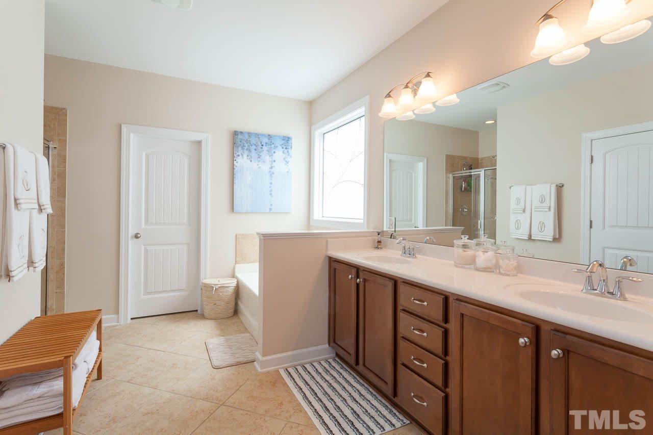 1014 Vino Drive Raleigh, NC 27607 - Photo 17 of 25 a spacious bathroom with a double vanity sink a mirror and a shower