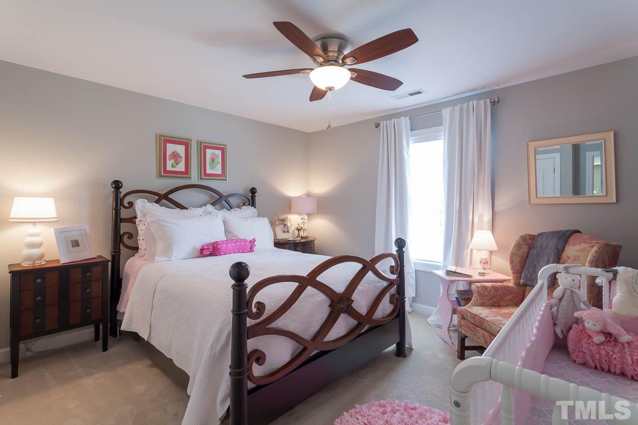 1014 Vino Drive Raleigh, NC 27607 - Photo 20 of 25 a bedroom with a bed and a chandelier