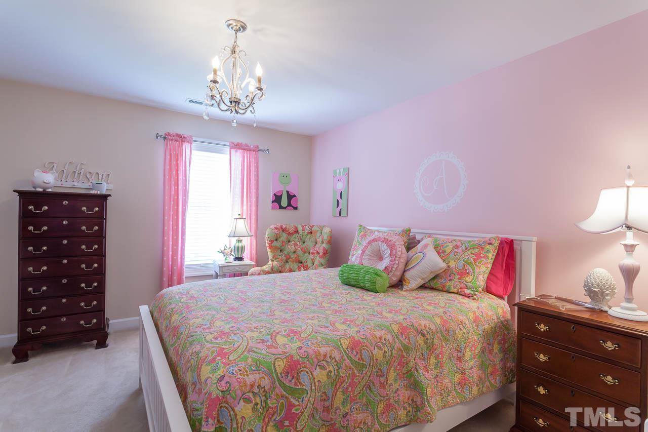 1014 Vino Drive Raleigh, NC 27607 - Photo 21 of 25 a bedroom with a bed a chandelier and a dresser