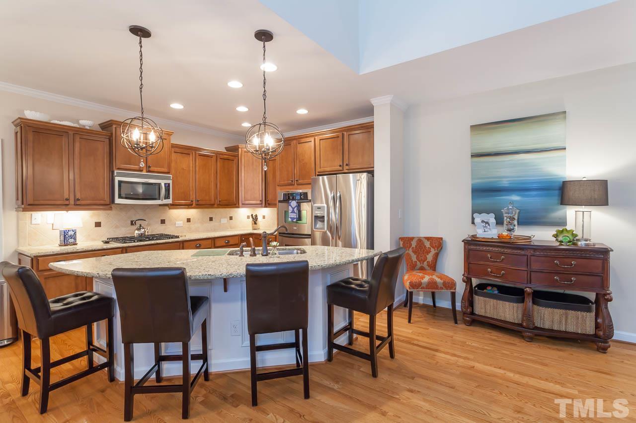 1014 Vino Drive Raleigh, NC 27607 - Photo 9 of 25 a kitchen with stainless steel appliances granite countertop a kitchen island a stove a table and chairs in it