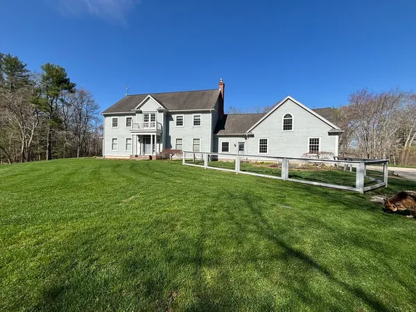 a view of a house with a big yard and large trees