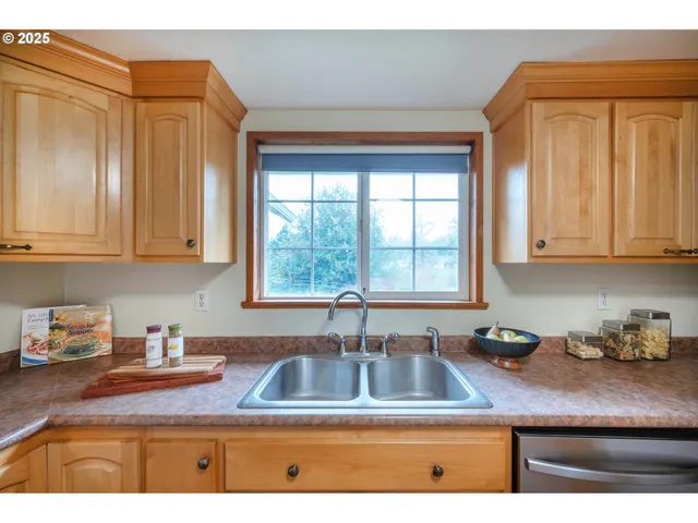 a kitchen with stainless steel appliances granite countertop a sink a cabinets and a window
