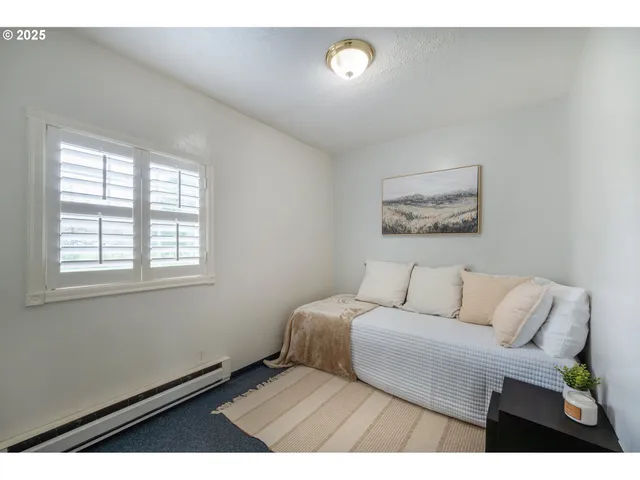 a bedroom with a bed and a painting on the wall