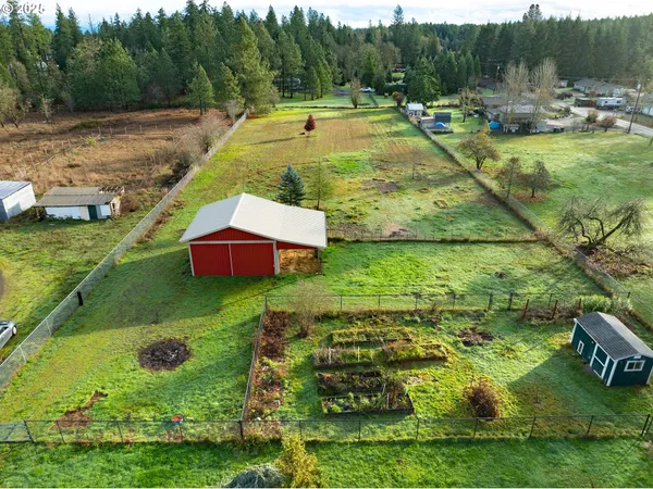 an aerial view of residential houses with outdoor space and trees