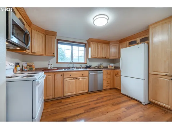 a kitchen with a refrigerator a microwave a sink and cabinets