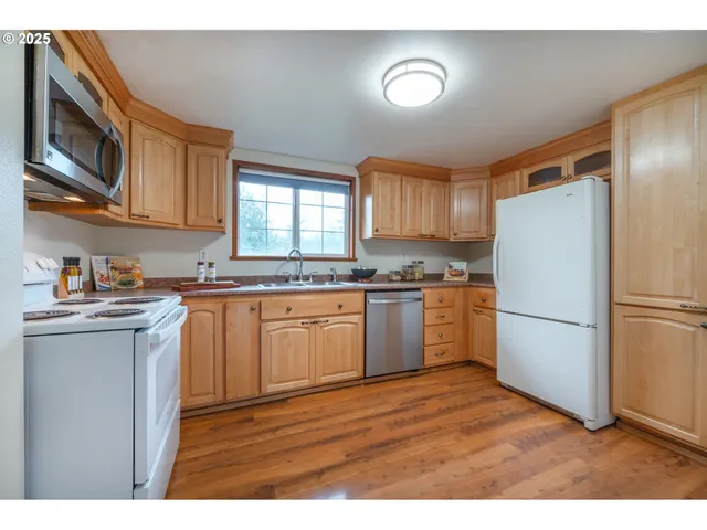 a kitchen with a refrigerator a microwave a sink and cabinets
