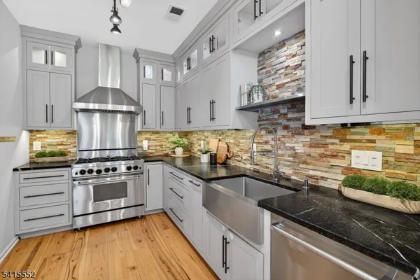 a kitchen with stainless steel appliances granite countertop a sink stove and cabinets